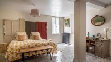 Une chambre à coucher avec un lit, un bureau, une chaise, un radiateur et une fenêtre.