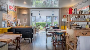 A cozy kitchen with a bar area, wooden furniture, and a view of the garden through the window.
