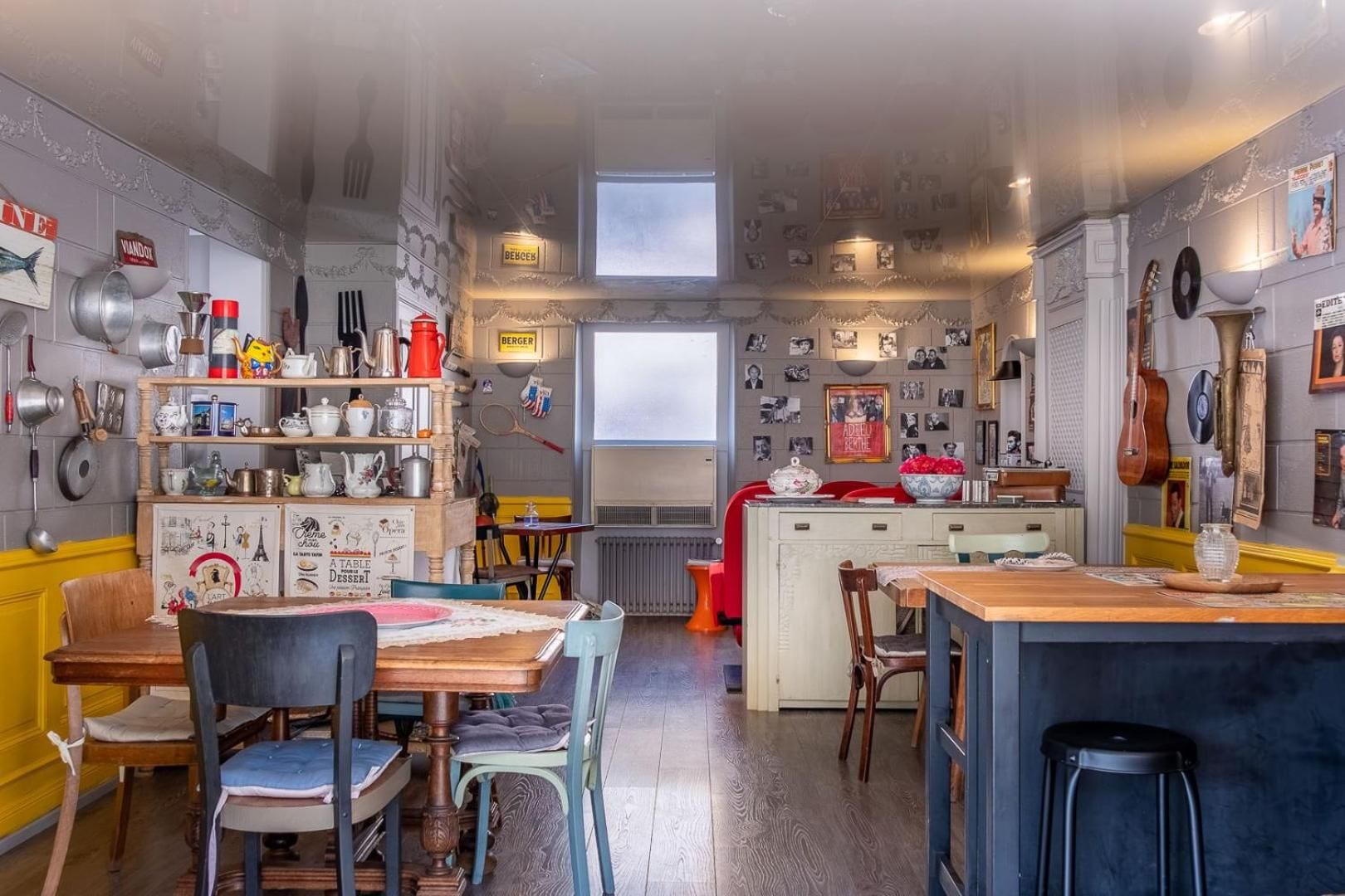 A kitchen with a central island, wooden chairs, and a dining table.