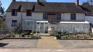 A two-story house with a large glass front and a chimney. - A La Lettre Thé (Valencisse)