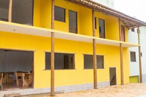 A yellow building with multiple windows and a covered outdoor area. - Pousada Irmãos da Serra (Santana do Riacho)