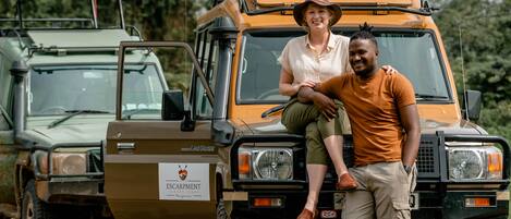 A safari vehicle with a logo on the side, indicating a safari or adventure tour service.
