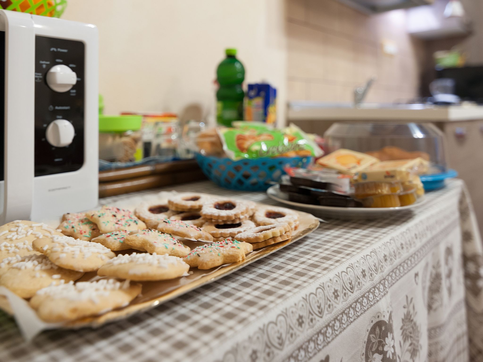 A buffet table with various baked goods and a microwave.