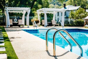 Una piscina al aire libre, sillones reclinables de piscina