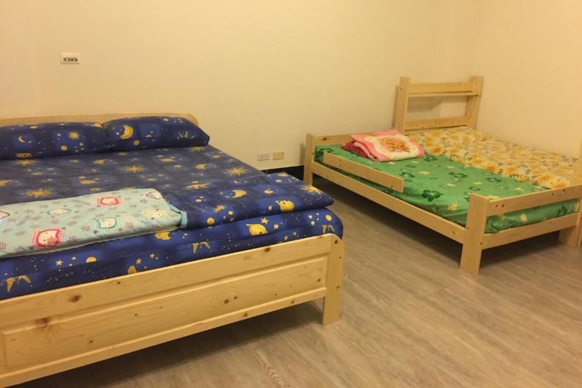 Two wooden bunk beds with star-patterned bedding, a wooden headboard, and a light-colored floor.