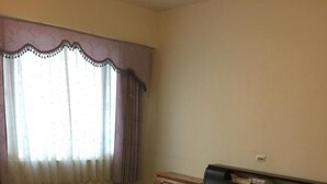 A bedroom with two beds, a nightstand, and a window with curtains. - Wish Enjoy Happy Homestay (Ligang)