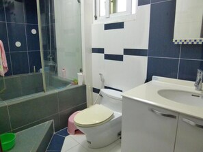 Ein Badezimmer mit Toilette, Waschbecken und Duschbereich.