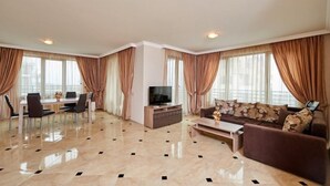 Uma sala de estar ampla com uma mesa de jantar, sofá e aparador para a TV.