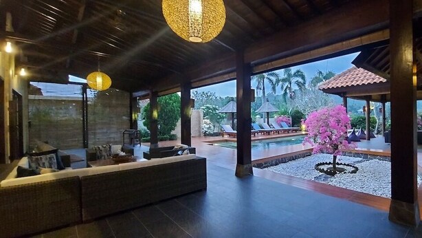A spacious indoor area with a pool, seating, and a view of the outdoors. - Bale Solah Lombok Holiday Resort (Batu Layar)