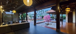 A spacious indoor area with a pool, seating, and a view of the outdoors. - Bale Solah Lombok Holiday Resort (Batu Layar)