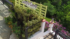 A sign for 'Sanctuario Natural Park' with a lush garden and a white fence. - Hotel Santo Cerro Natural Park  (La Vega)