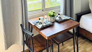 A small room with a wooden table, two chairs, a bed, and a window with a view of greenery. - Hotel Santo Cerro Natural Park  (La Vega)