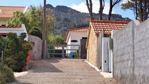 Un camino de grava que conduce a un edificio con techo de tejas y un letrero que dice "Villa Mary".