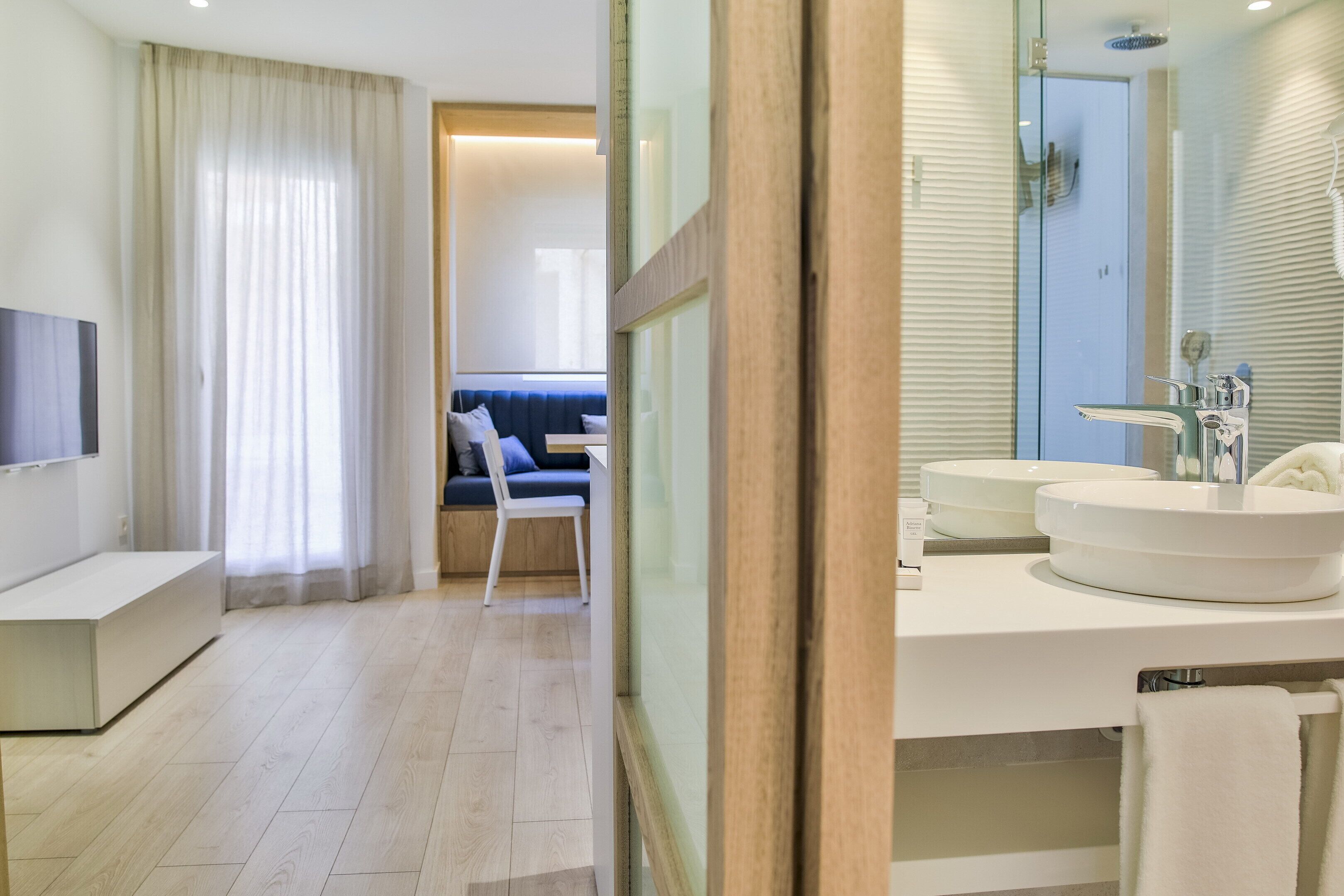 A modern bathroom with two sinks, a mirror, and a shower.