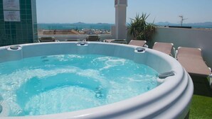 A hot tub on a rooftop with a view of the city and mountains. - Apartamentos 525 (Los Alcázares)