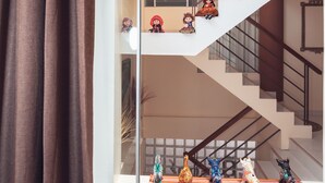 A modern interior with a staircase, glass railings, and decorative figurines. - Hotel Las Quenas (Cusco)
