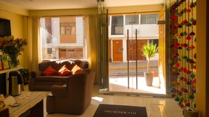 A hotel lobby with a sofa, a coffee table, a doormat, and a potted plant. - Hotel Las Quenas (Cusco)