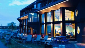 A modern building with large windows and outdoor seating. - Blue Wave Inn (Ashland)