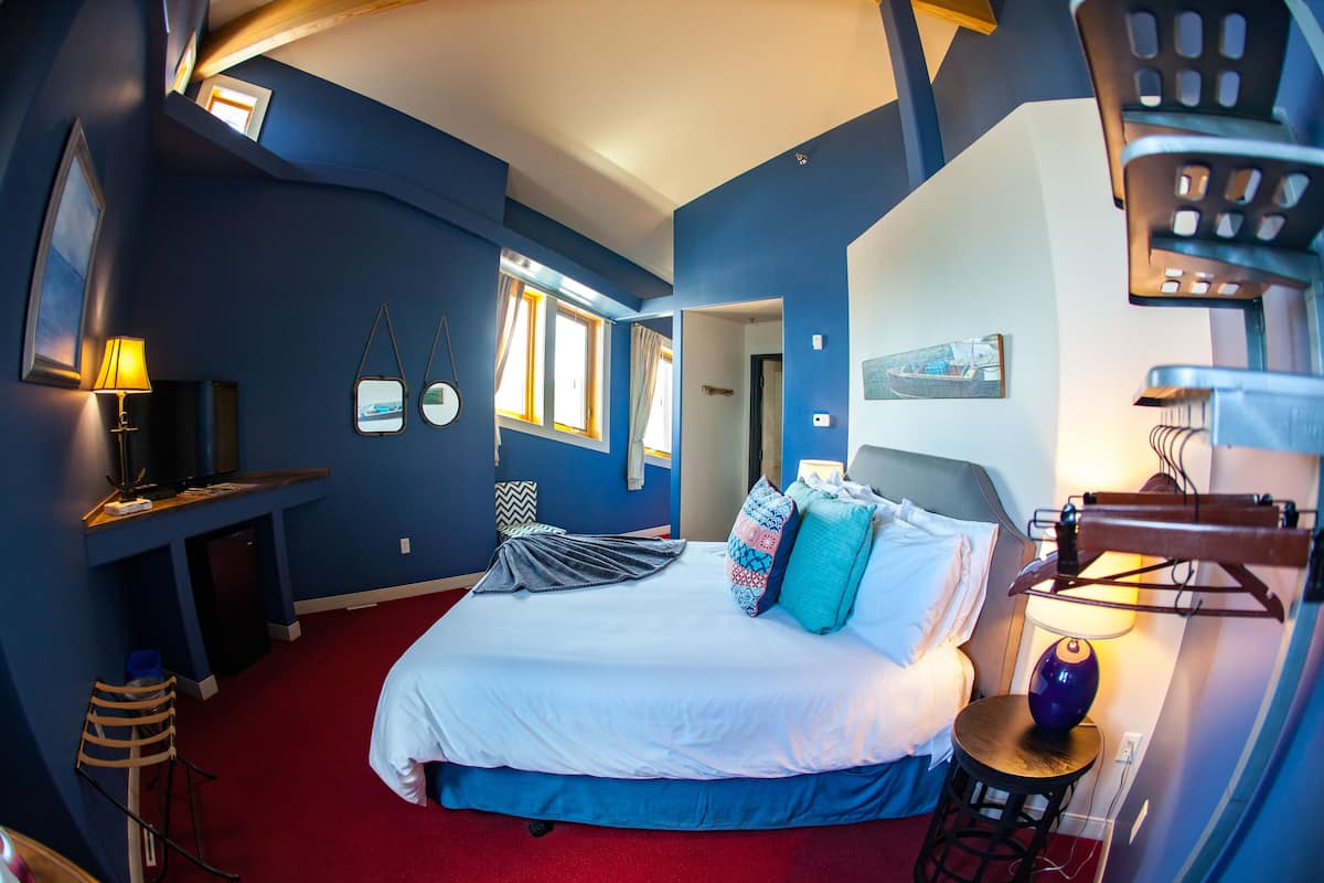 A room with a bed, a desk, a chair, and a window.