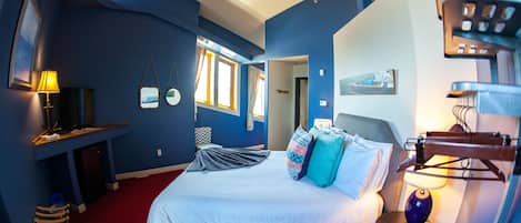 A room with a bed, a desk, a chair, and a window.