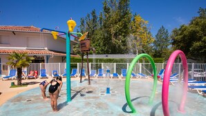 Um parque aquático com piscina, toboáguas e espreguiçadeiras.