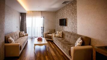 A modern living room with two sofas, a coffee table, and a TV mounted on the wall.