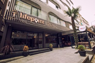 Un hotel con facciata moderna, ampie vetrate e zone relax all'aperto.