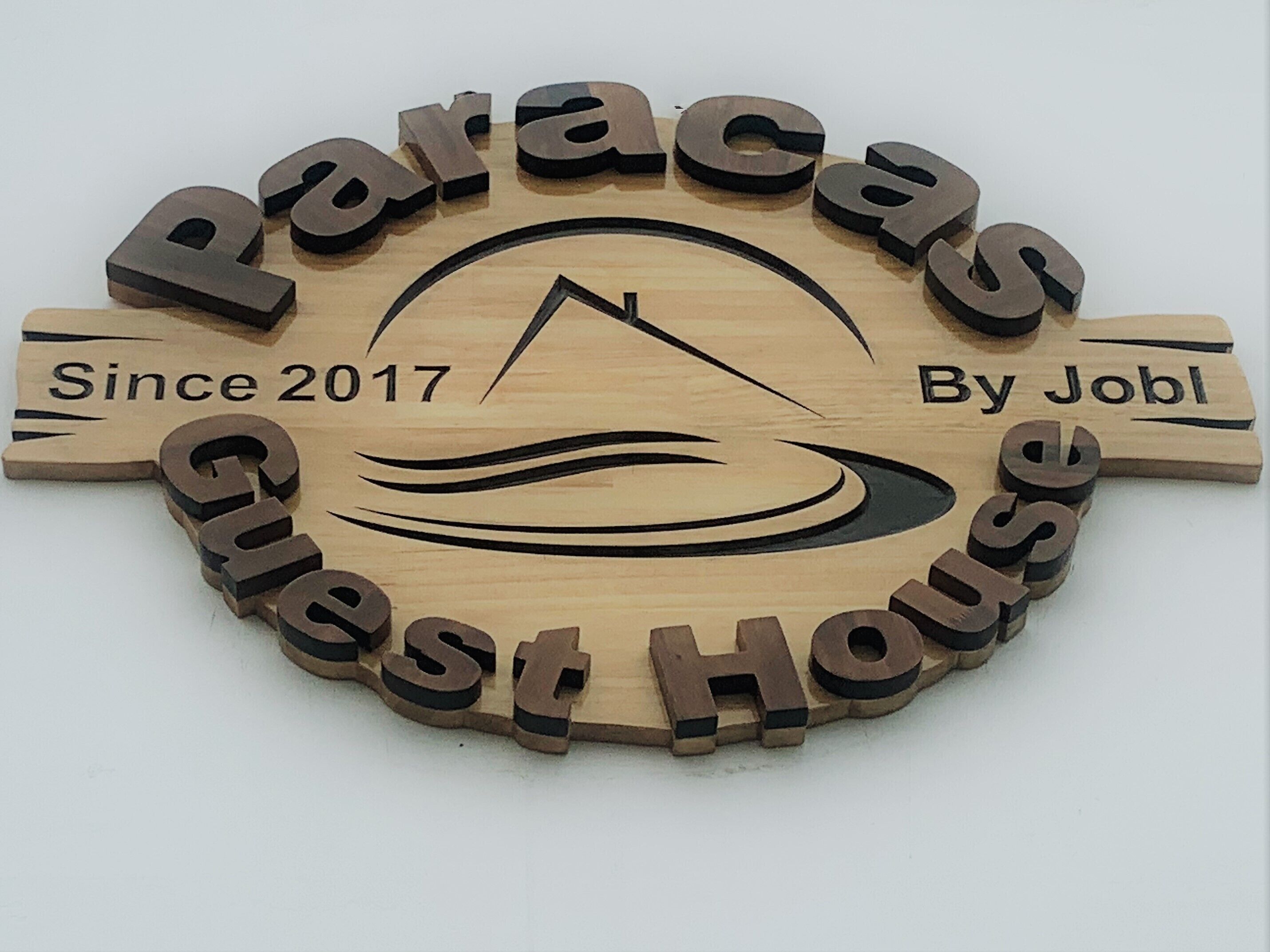 Et træskilt med teksten "Paracas Guest House" og "Since 2017 By Jobl".