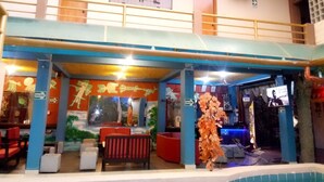 A hotel lobby with a pool area, seating, and a staircase. - Hotel Daylu (Punchana)