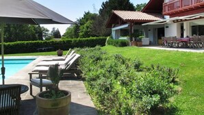 A house with a swimming pool, outdoor furniture, and a well-maintained garden. - House / Villa - ARBONNE (Arbonne)