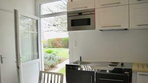 A modern kitchen with a built-in oven, microwave, and sink.
