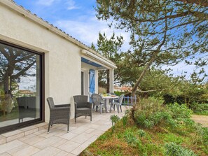 A patio area with outdoor seating, a covered section, and a garden with various plants. - 150m from the beach - Maison vendéenne for 6 (Bretignolles-sur-Mer)