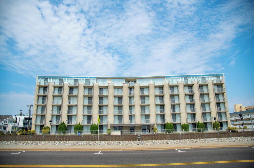 Un hotel de varios pisos con fachada simétrica, ventanas amplias y techo plano.