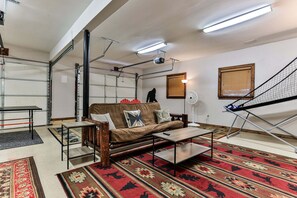 A living room with a sofa, coffee table, and patterned rugs.