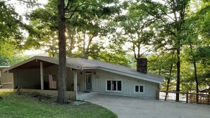 A single-story house with a sloped roof, a front porch, and a small front yard. -  Cozy Lake Front Cottage w/dock, perfect family retreat! (Camdenton)