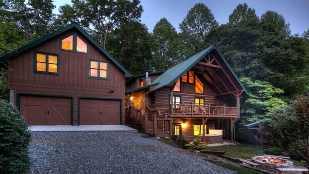 A two-story log cabin with a front deck and a fire pit area. - Water's Edge | Blue Ridge, GA (Blue Ridge)
