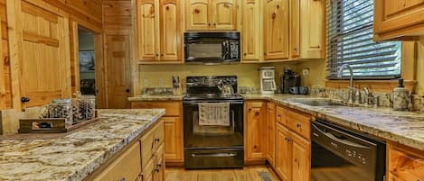 A kitchen with wooden cabinets, a microwave, stove, and dishwasher.