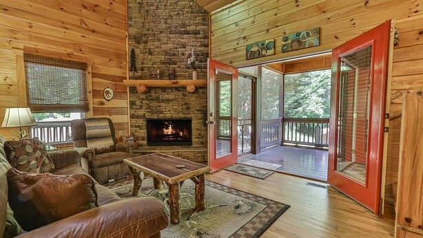 A cozy cabin interior with a fireplace, wooden furniture, and a balcony. - Whitetail Ridge | Ellijay, GA (Ellijay)