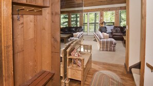 Ein Holzinterieur mit einer Couch, Sesseln und einer Bank.