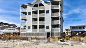A multi-story building with balconies, located near a sandy beach. - Sea Watch VIII 102 - Two Bedroom, Two Bath Oceanfront Condo (Garden City Beach)