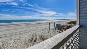 A beach view from a balcony with a wooden railing, a pier in the distance, and a clear sky. - Sea Watch VIII 102 - Two Bedroom, Two Bath Oceanfront Condo (Garden City Beach)
