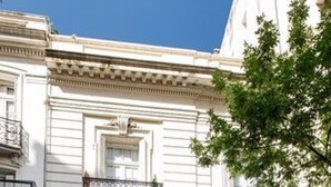 A building with a classic architectural style, featuring a central entrance with a decorative arch and a balcony above it. - Patios de Recoleta (Buenos Aires)