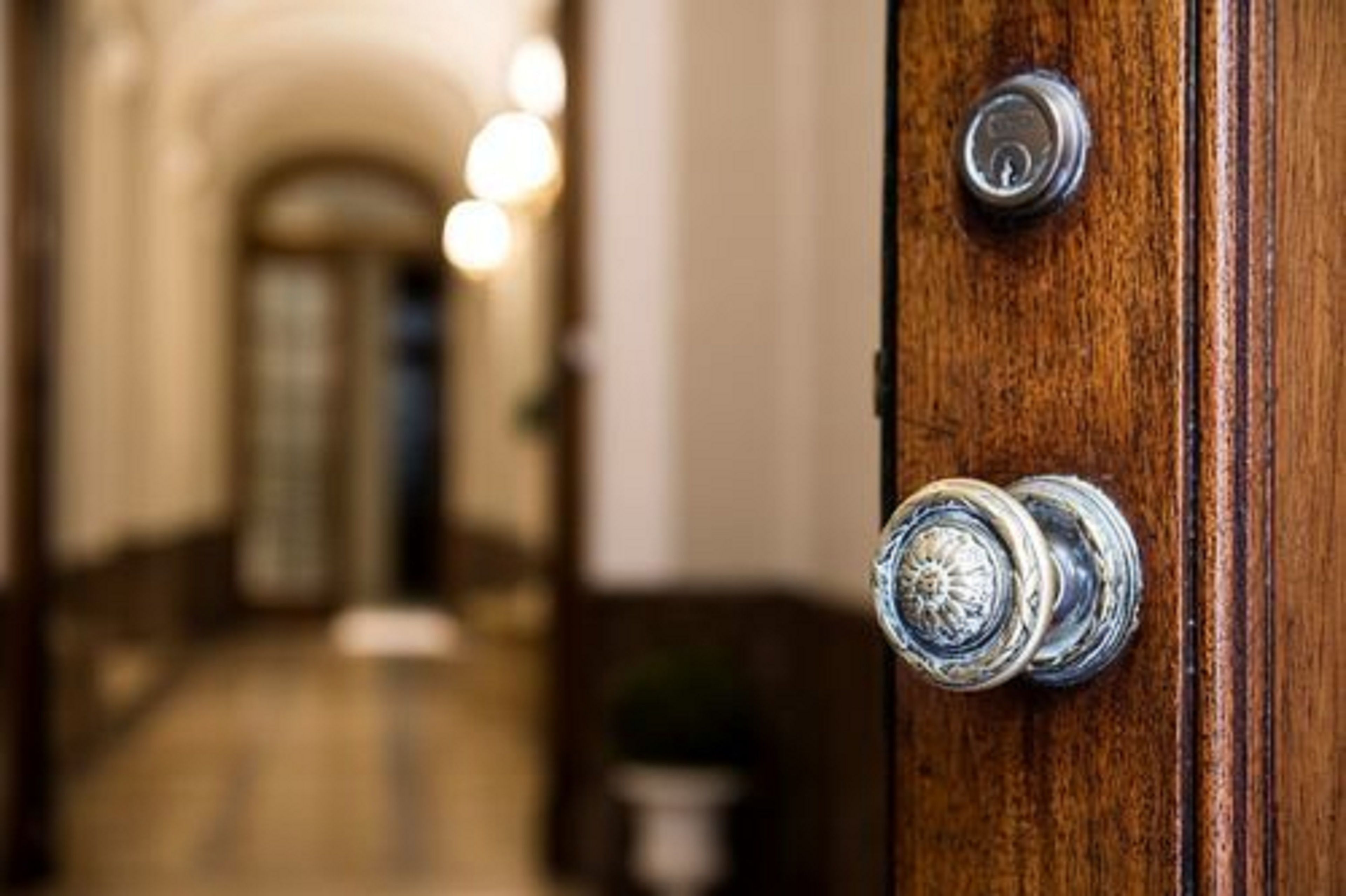 A wooden door with a round, metallic handle and a keyhole.