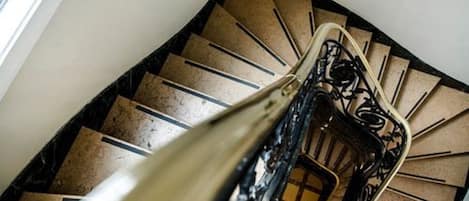 Una escalera de caracol con barandilla y suelo estampado.