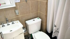 Ein Badezimmer mit einem weißen Waschbecken, einer Toilette und einer Duschvorhang.