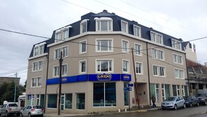 Ein mehrgeschossiges Gebäude mit einer blauen Fassade, im Erdgeschoss befindet sich ein Geschäft mit der Aufschrift "GRIDO HELADO".