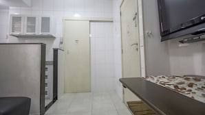 A small, clean room with a tiled floor, a bed with a patterned blanket, a television mounted on the wall, and a door with a 'No Smoking' sign. - LineRio Copacabana Residence 189 (Rio de Janeiro)