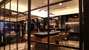 A modern kitchen with a central island, wooden chairs, and built-in shelves. - VN Bela Cintra (Sao Paulo)