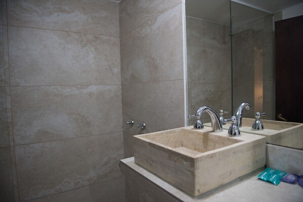 Une salle de bain avec deux lavabos, un grand miroir et des murs carrelés.