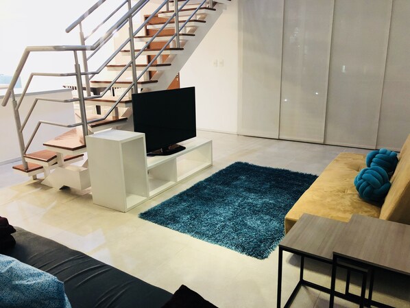 Departamento de diseñador, 2 habitaciones, vista a la alberca, junto a la alberca | Área de sala de estar | Televisión de pantalla plana de 45 pulgadas con canales vía satélite 